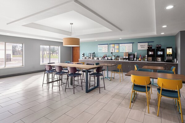 A modern restaurant with a bar area, multiple seating options, and a view of the outdoors. - Garner Hotel Brookings by IHG (Brookings)