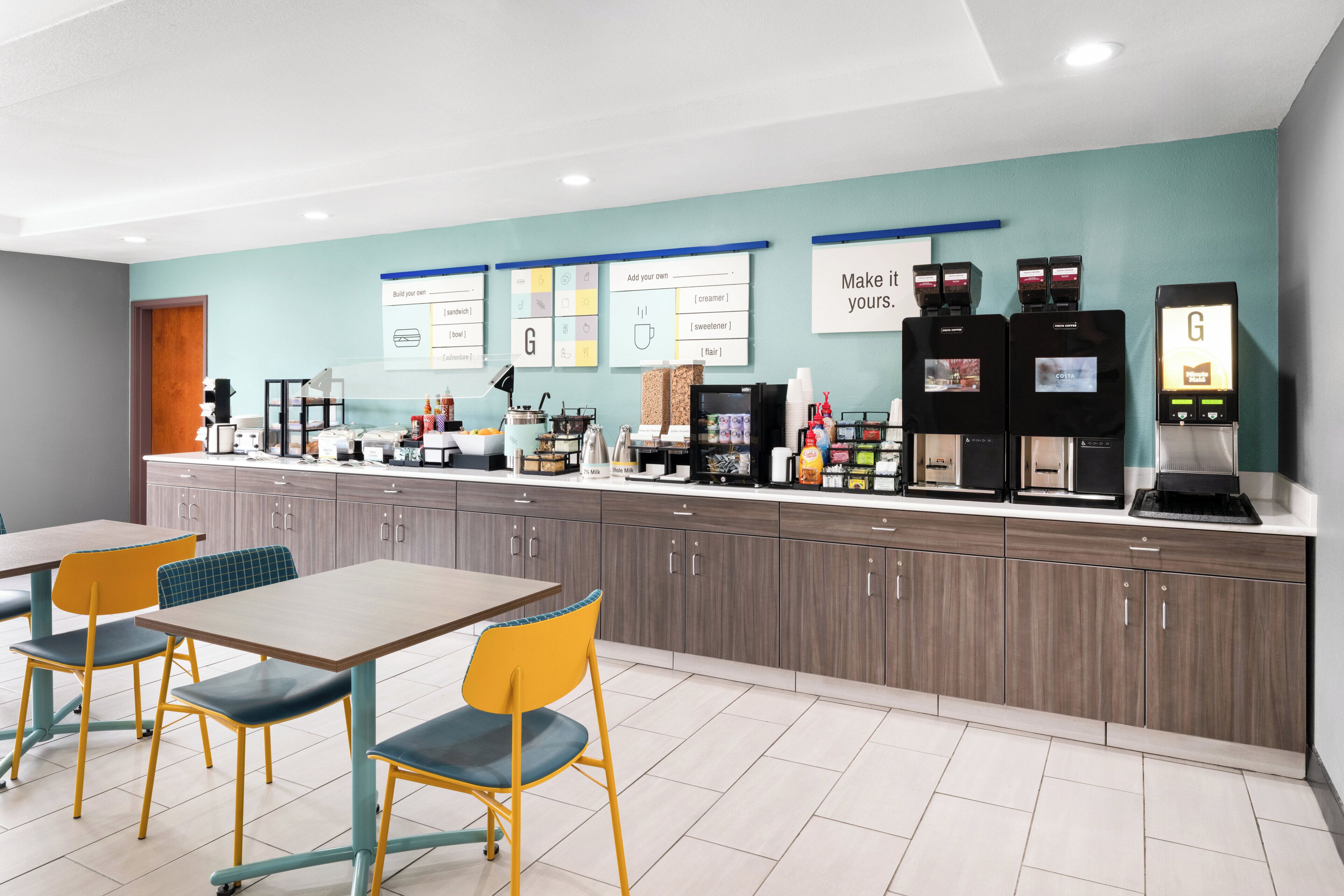 A modern kitchenette with a coffee machine, tea maker, and a GIFT card dispenser.