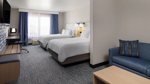 Une chambre d’hôtel avec deux lits, un bureau, une télévision, un canapé et une fenêtre avec des rideaux.