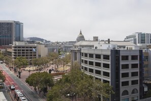 A cityscape with modern buildings, a prominent dome structure, and a busy street with vehicles and pedestrians.