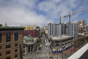 A cityscape with a mix of historic and modern buildings, a prominent construction crane, and a clear sky.