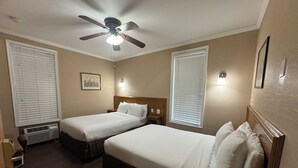 A hotel room with two single beds, a ceiling fan, and a window with blinds. - District Hotel (Washington)