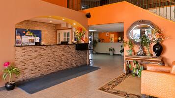 Welcome to our lobby, featuring a reception desk, comfortable seating area, and lush greenery.