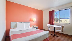 A hotel room with a bed, a desk, and a chair. - Motel 6 Colby, KS (Colby)