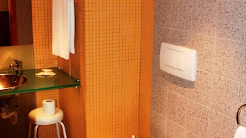 Un bagno con il water, bidet, lavabo e cabina doccia in vetro.