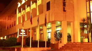 A hotel with a prominent sign, multiple balconies, and a staircase leading to the entrance. - Hotel das Taipas (Guimarães)