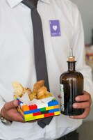 A person holding a colorful box of food and a bottle.