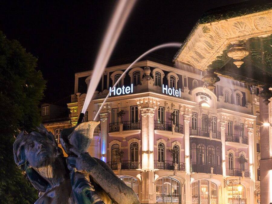 A historic hotel with ornate architecture, including columns and balconies, and a prominent sign indicating it is a hotel.