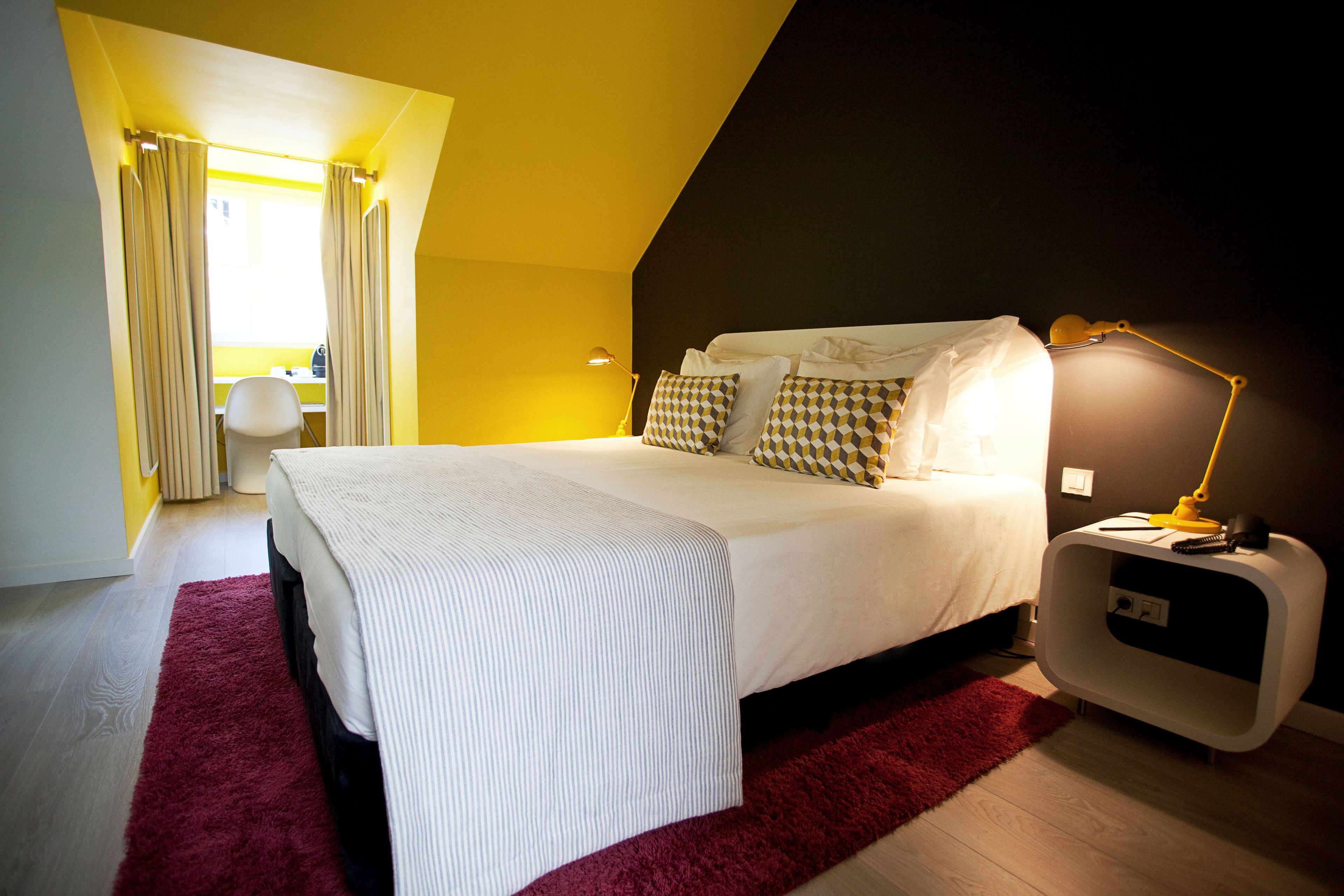 A bedroom with a bed, a desk, and a chair.