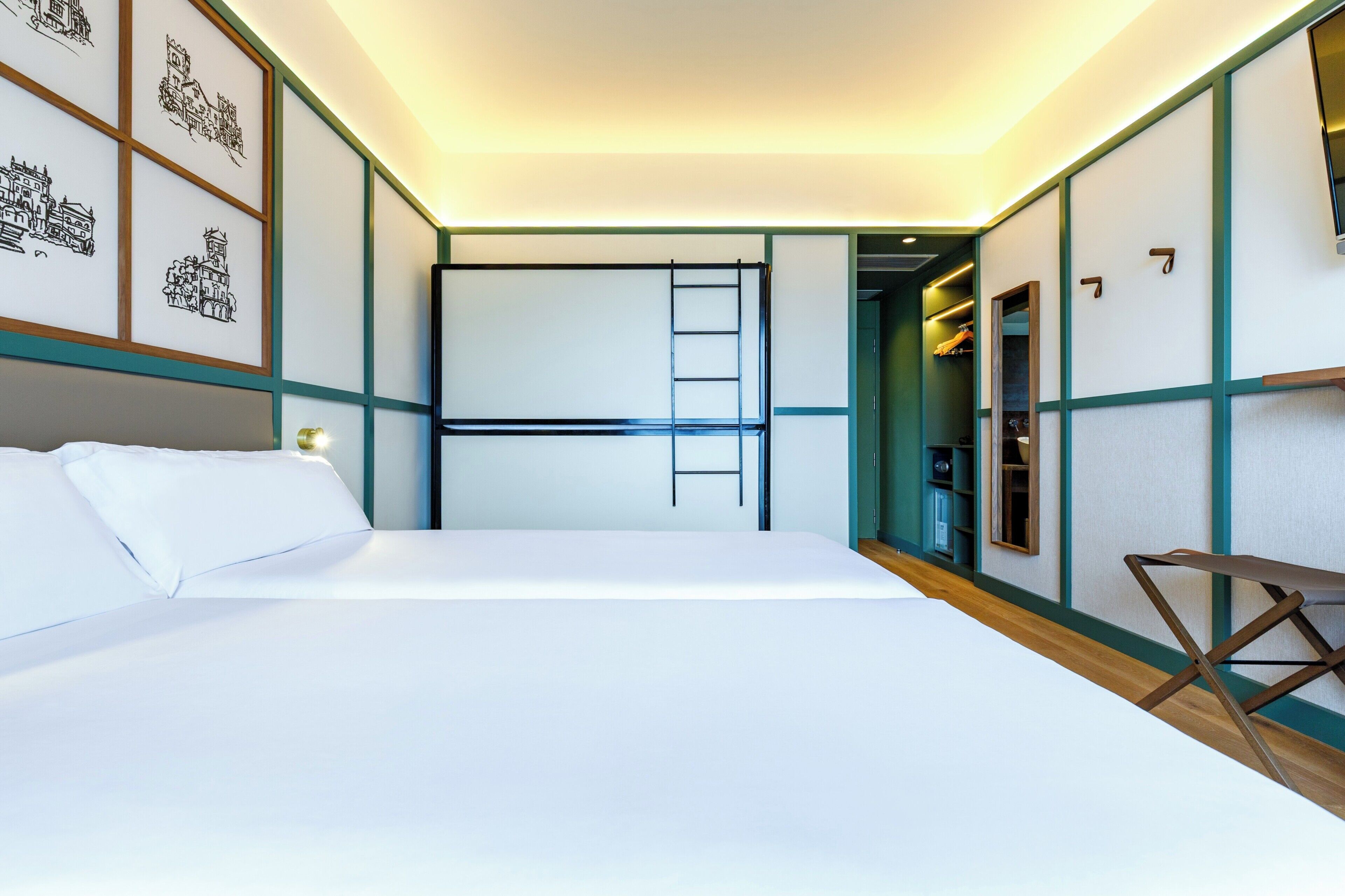 A bedroom with a bed, a ladder, a desk, and a wardrobe.