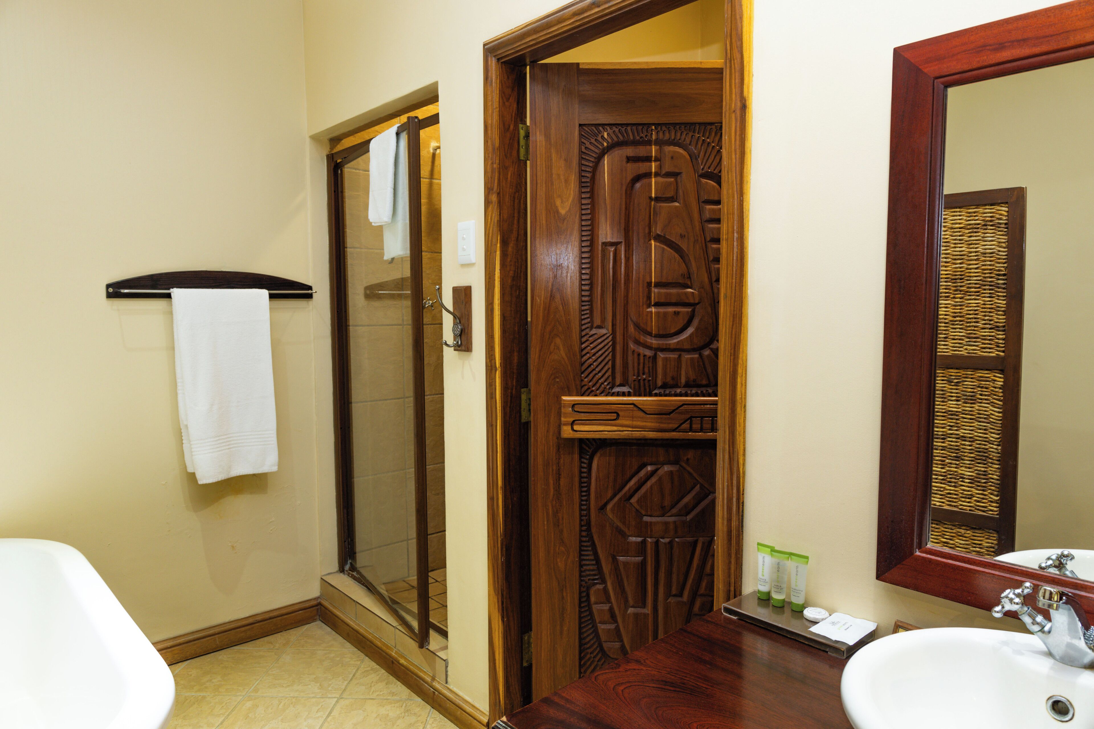 Une salle de bain avec une douche, un lavabo et un miroir.
