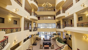 A multi-level atrium with a central open space, balconies, and seating areas. - Premier Hotel Regent (East London)