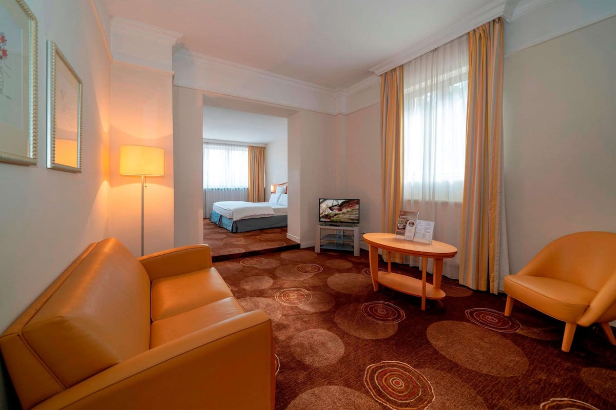 Ein Hotelzimmer mit einem Bett, einem Fernseher, einem Schreibtisch und zwei Stühlen.