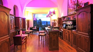 A bar area with wooden furniture, a view of the outdoors, and a large window.