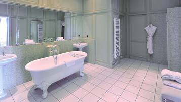 A bathroom with a freestanding bathtub, a sink, and a mirror.