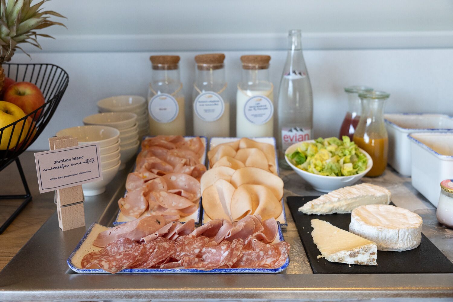 A buffet with various meats, cheeses, and condiments.