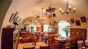 A cozy restaurant with wooden tables and chairs, hanging chandeliers, and framed pictures on the walls. - Hotel Regensburg Herzogshof am Dom (Regensburg)