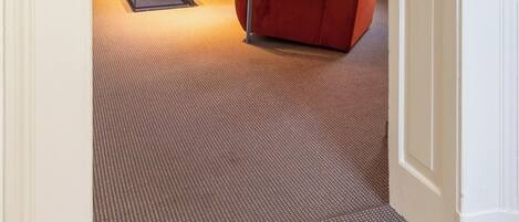 Una sala de estar moderna con un sofá, un sillón y una mesita baja con fruta.