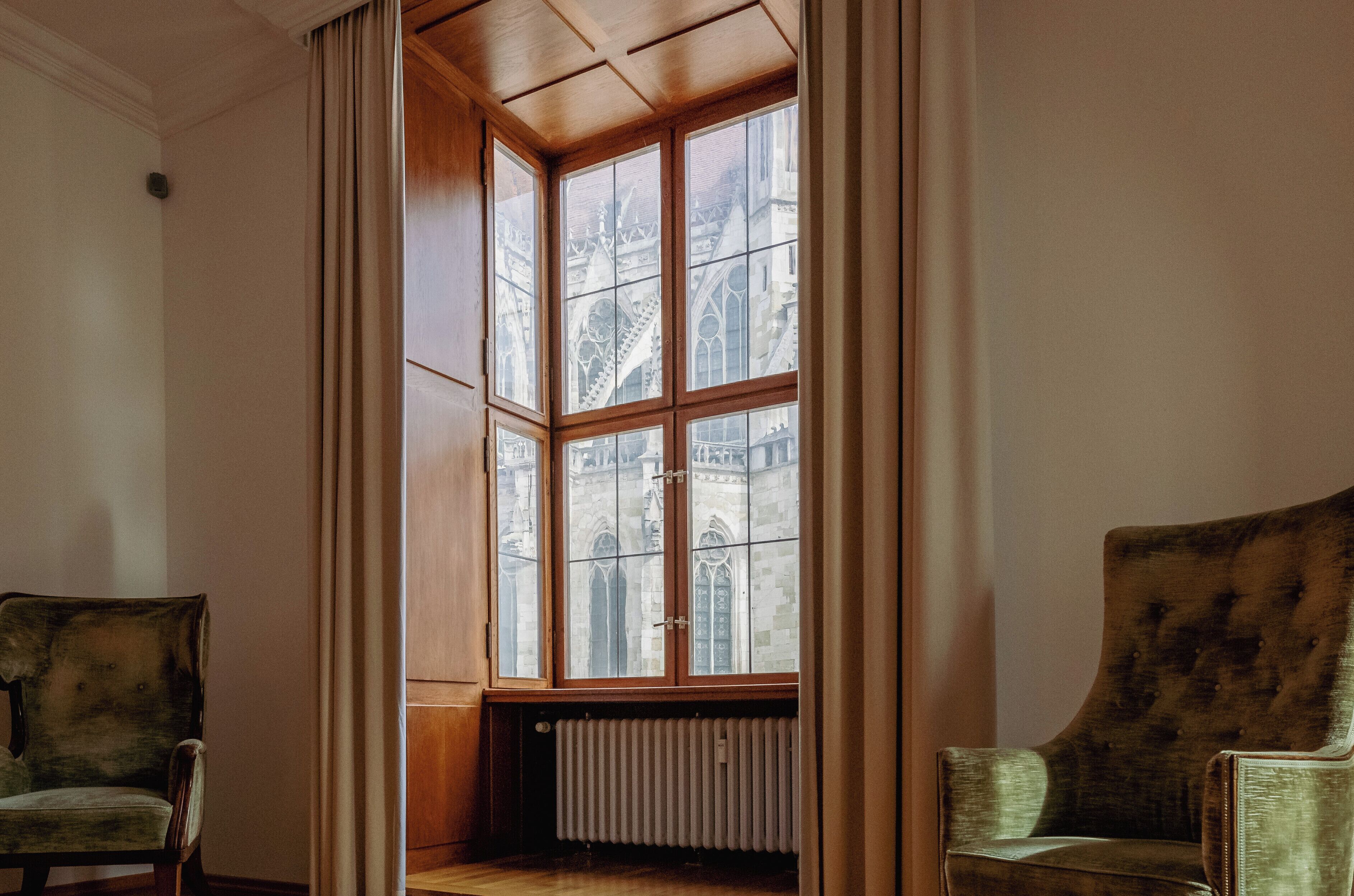 Quarto com um amplo parapeito, um radiador e duas poltronas estofadas.