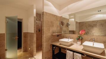 Une salle de bain moderne avec deux lavabos, un grand miroir et un espace douche.