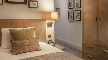 Une chambre d’hôtel avec un lit, une table de chevet, une lampe et une armoire.