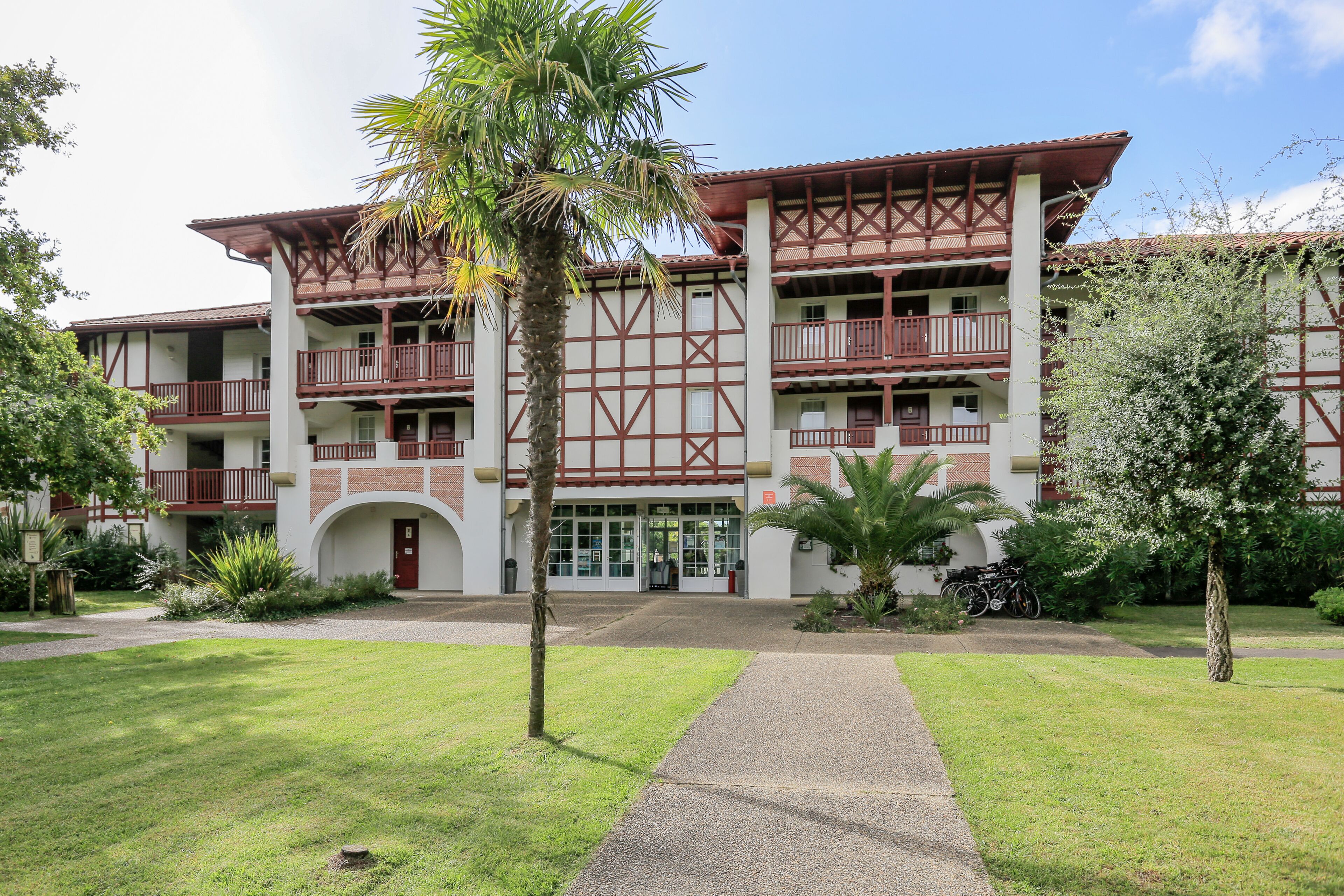 A two-story building with a traditional architectural style, featuring balconies and a central entrance.