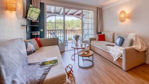 Ein modernes Wohnzimmer mit zwei Sofas, einem Couchtisch und einem Balkon mit Blick.
