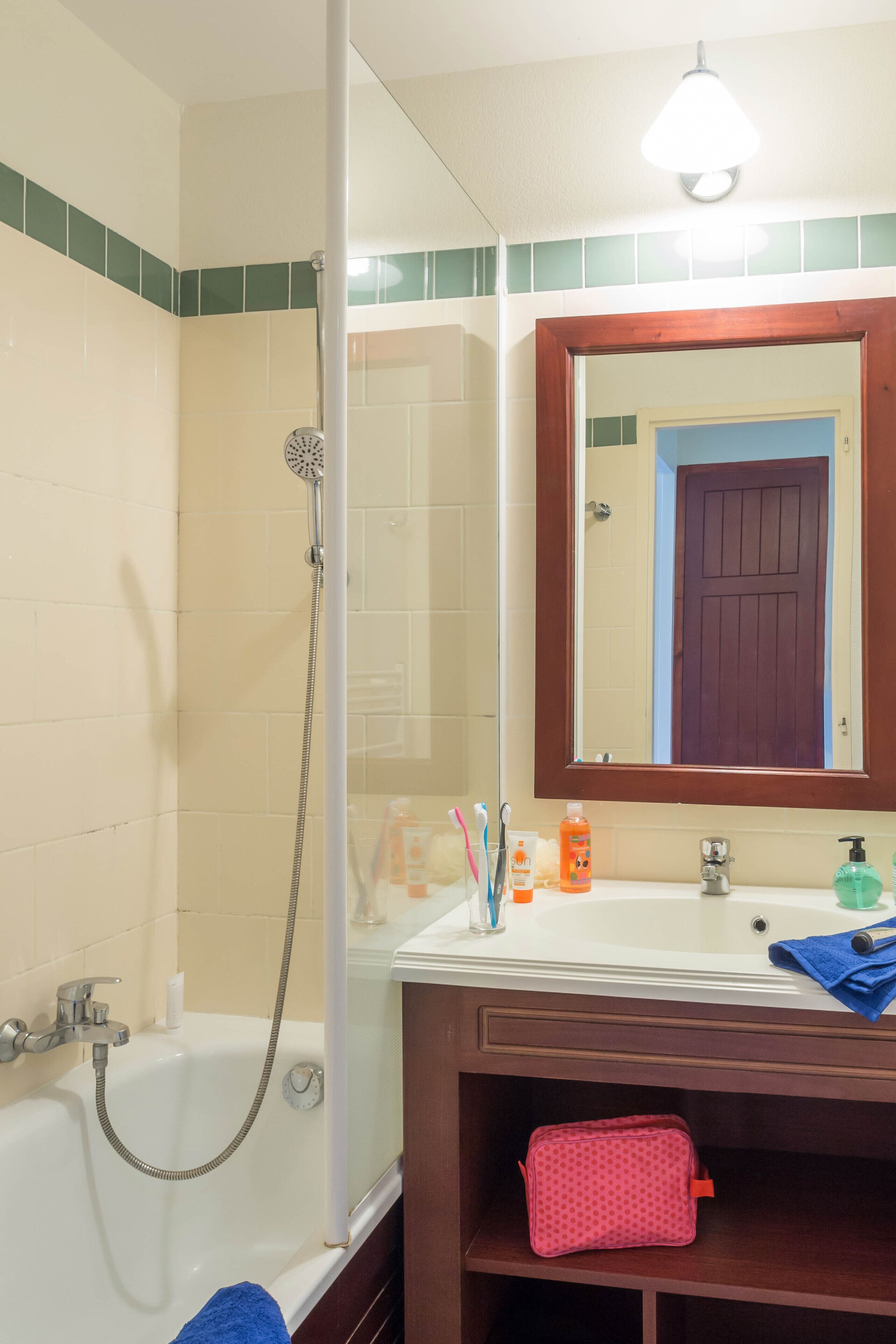 Un baño con bañera, ducha, lavamanos y espejo.