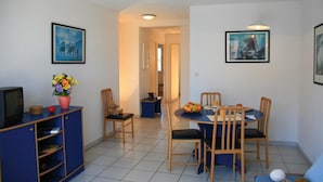 A compact living space with a dining area, a small kitchenette, and a TV. - Résidence Lagrange Vacances Villa Barbara (Cavalaire-sur-Mer)