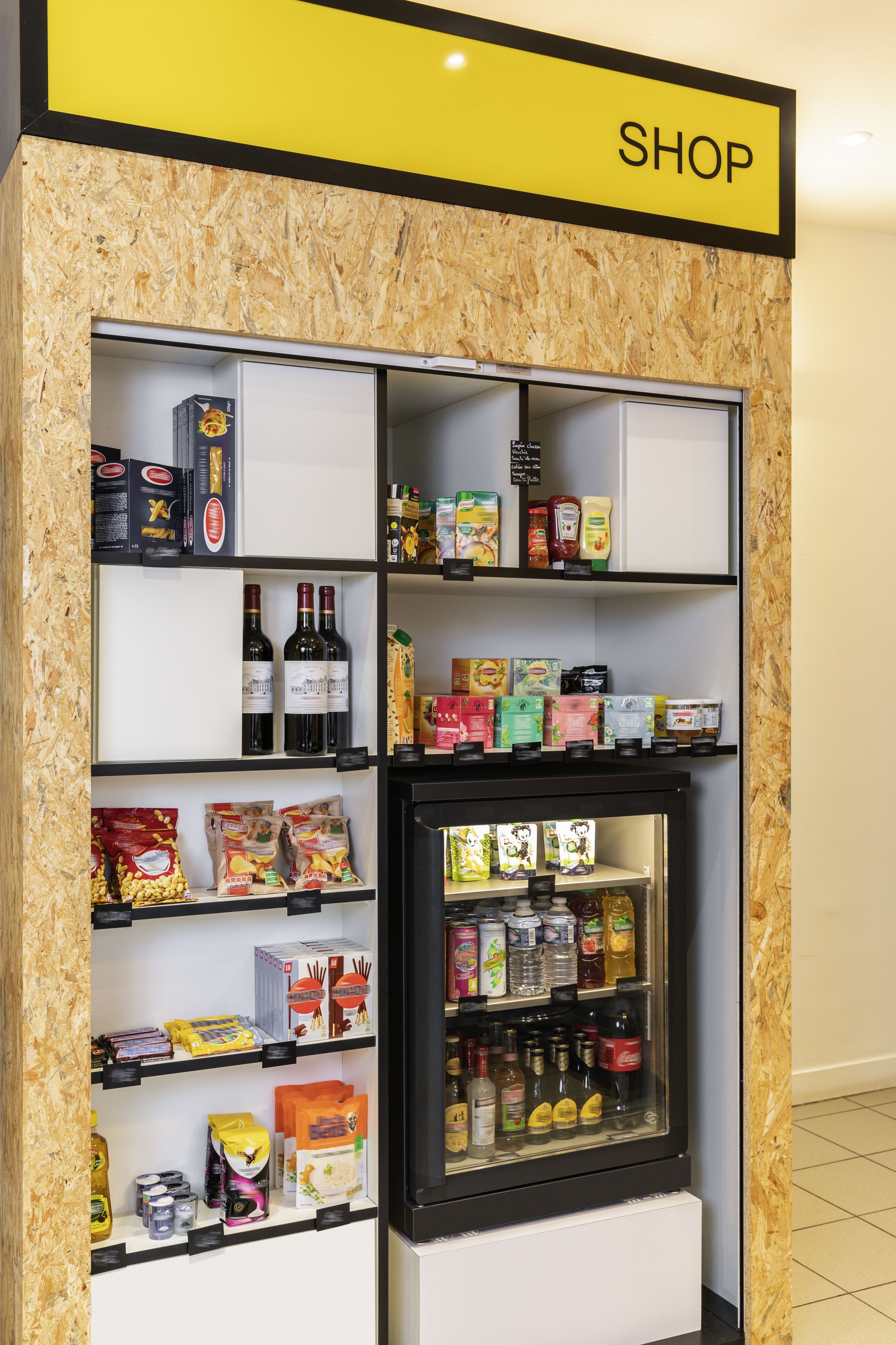 Una tienda con estantes llenos de aperitivos, bebidas y salsas.