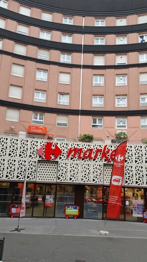 Un edificio con un letrero que dice 'Les L'Aurées HOTEL RESIDENCE' y un letrero que indica 'mercado' en la parte delantera.
