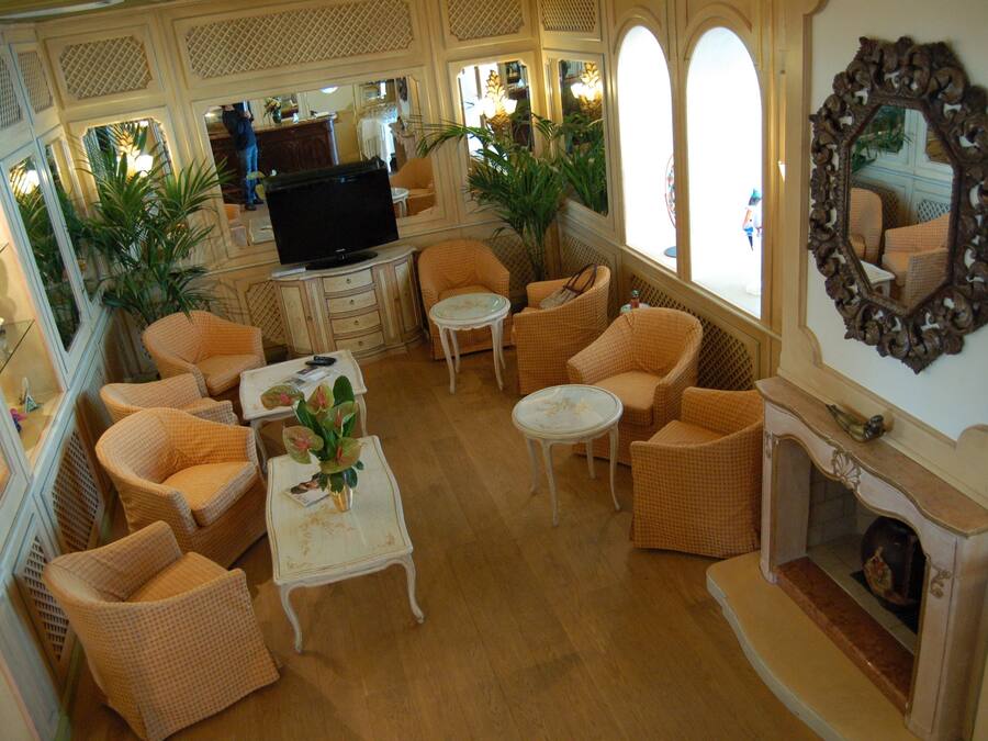 A spacious living room with wicker furniture, a television, and a fireplace.