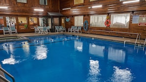 An indoor swimming pool with clear water, surrounded by wooden walls and a lifebuoy on the wall. - Ambassador Inn & Suites (South Yarmouth)