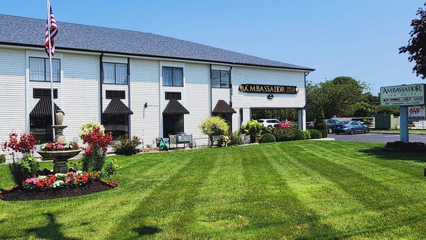 A two-story building with a sign for 'Ambassador Inn & Suites'. - Ambassador Inn & Suites (South Yarmouth)
