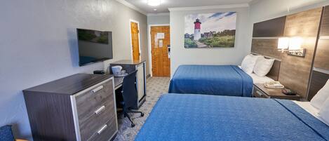 Una habitación de hotel con dos camas, un escritorio, una silla, un televisor y un cuadro en la pared.