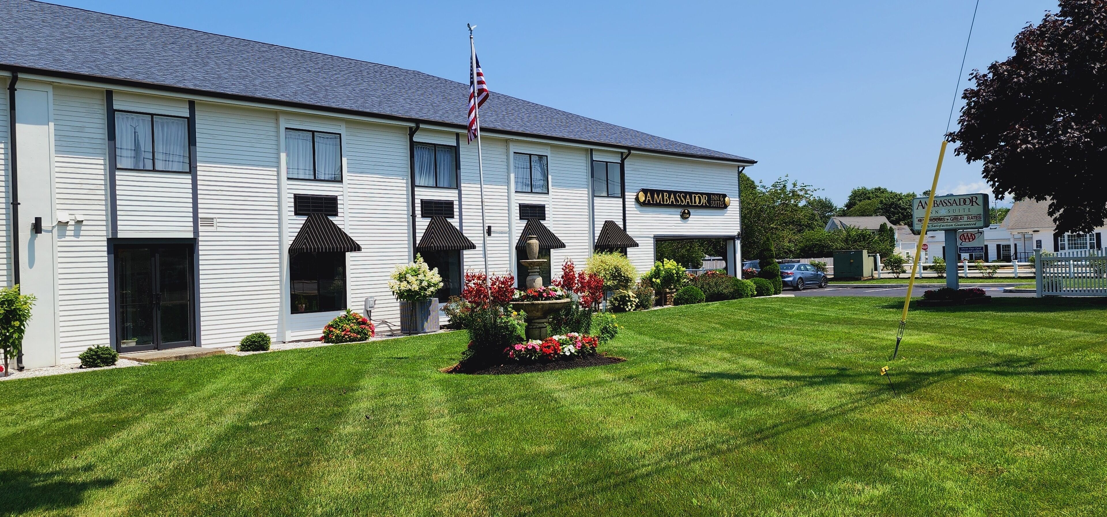 A two-story building with a sign reading "AMBASSADOR" and "Pine & Suites."