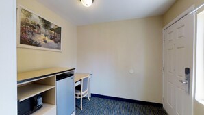 A small, clean room with a desk, chair, and a door.