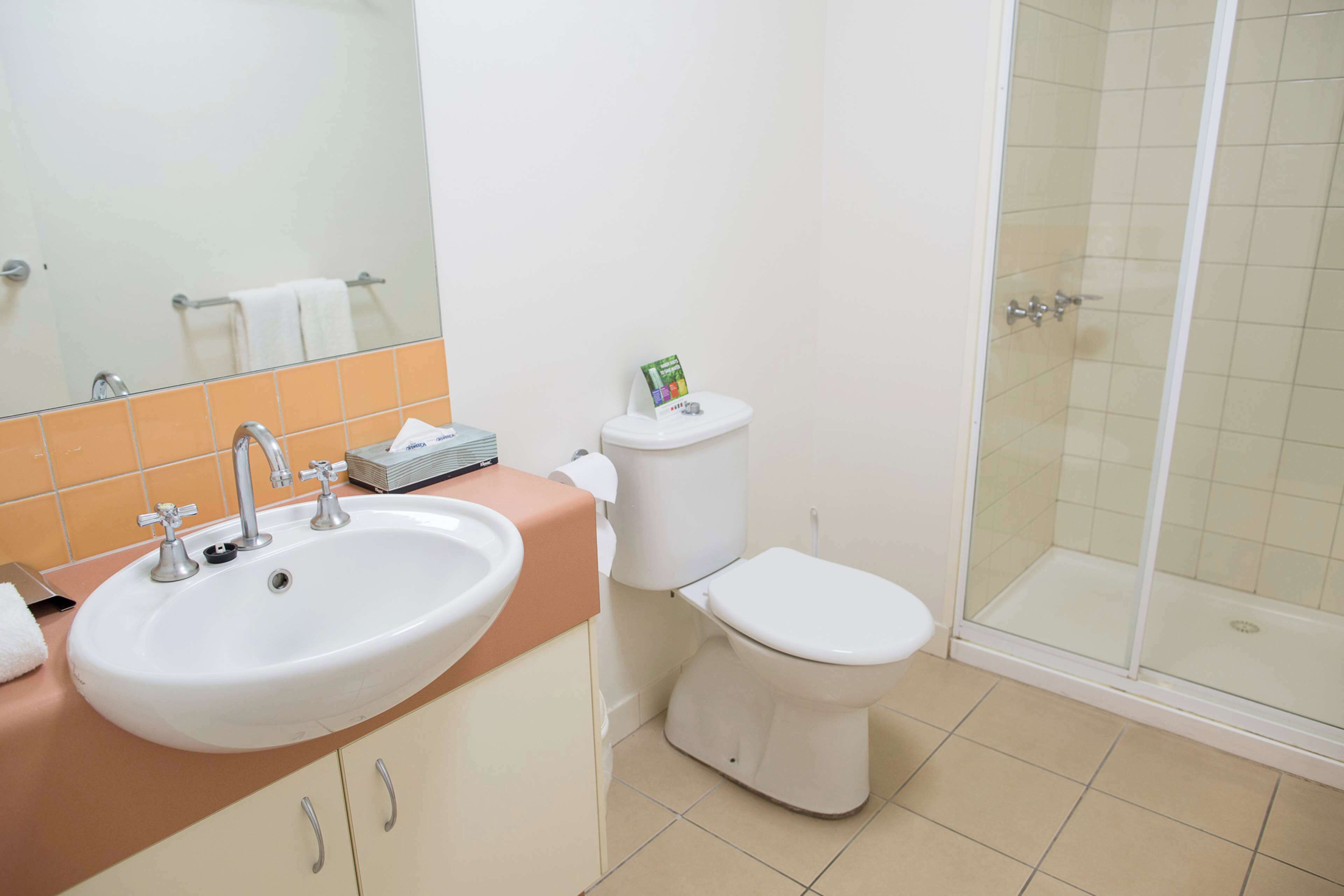 Un baño con lavabo, inodoro y cabina de ducha de vidrio.
