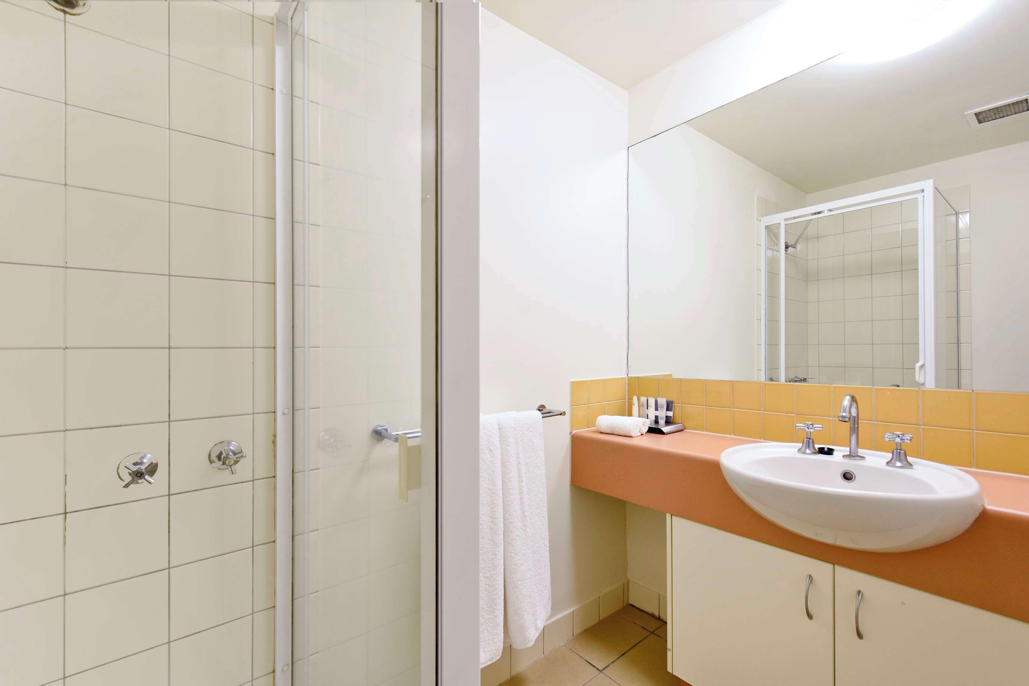 A bathroom with a shower, a sink, and a mirror.