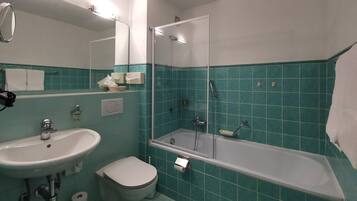 Un baño con lavamanos, inodoro y ducha.
