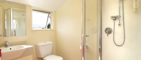 A bathroom with a toilet, sink, and shower.