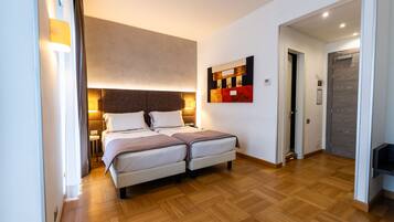 Ein modernes Schlafzimmer mit einem großen Bett, Nachttischlampen und Holzboden.