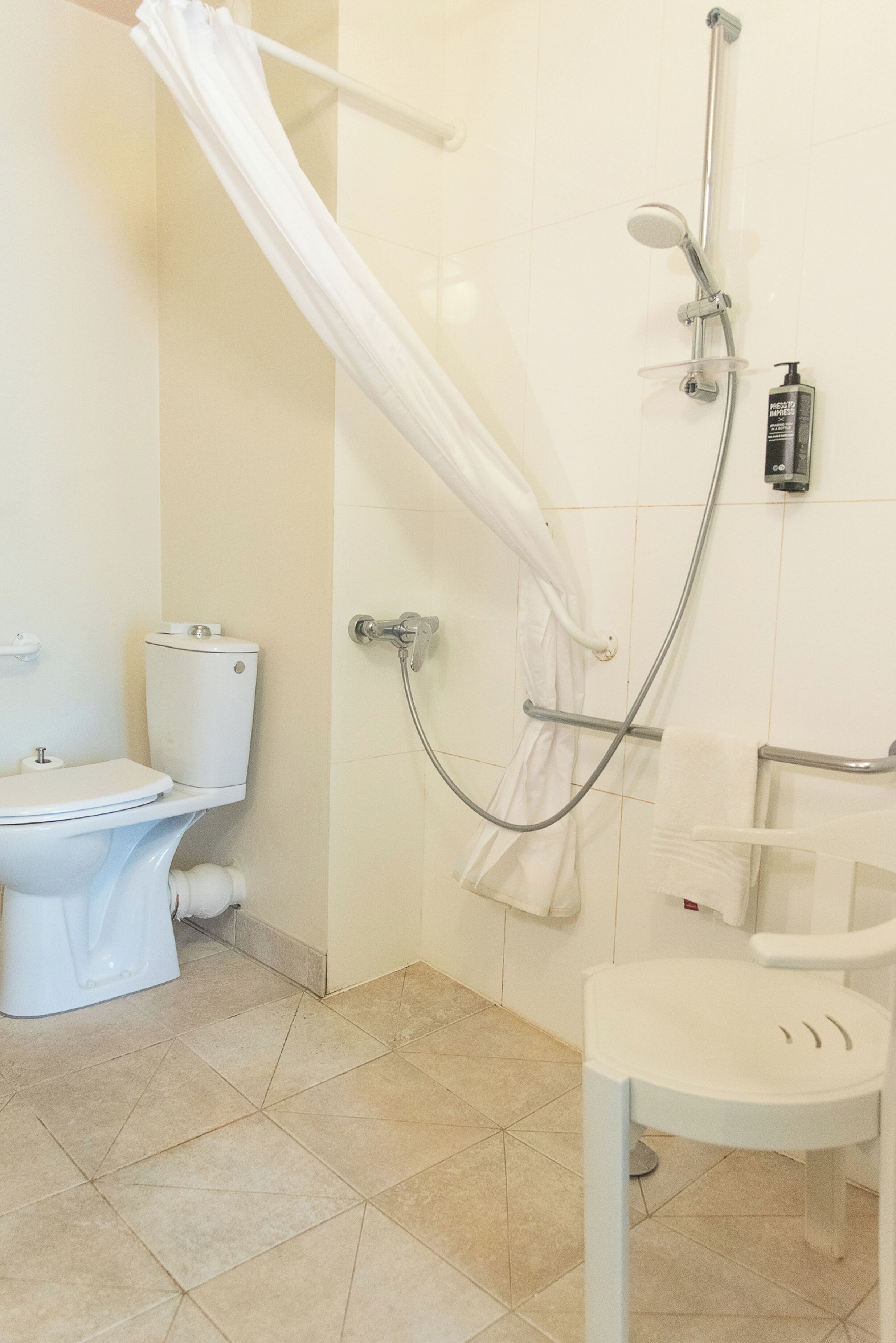 Une salle de bain avec douche, toilettes et lavabo.
