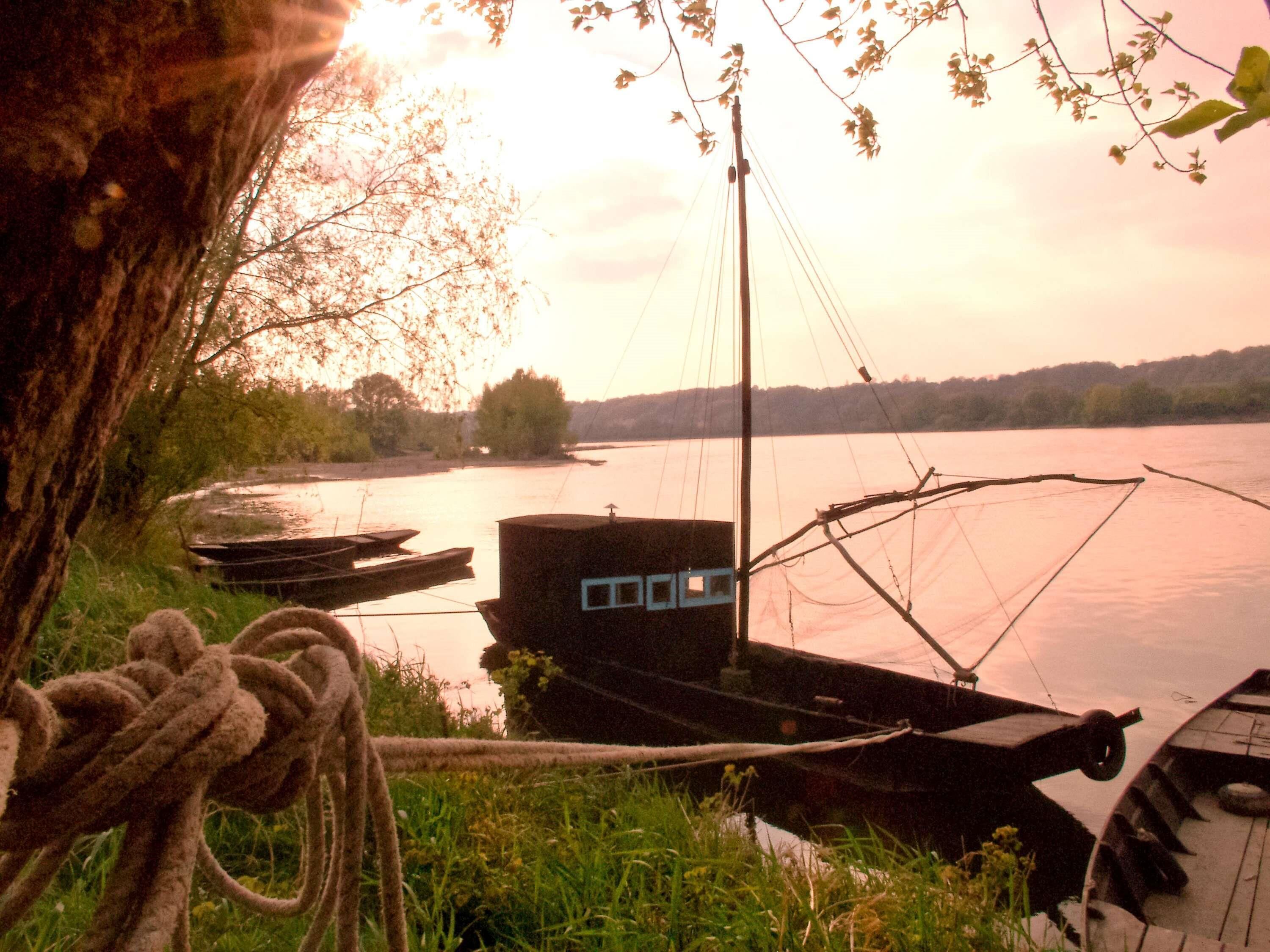 A dock with boats, a rope, and a building with a window.