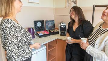 A kitchenette area with a coffee machine, a kettle, and a small refrigerator.