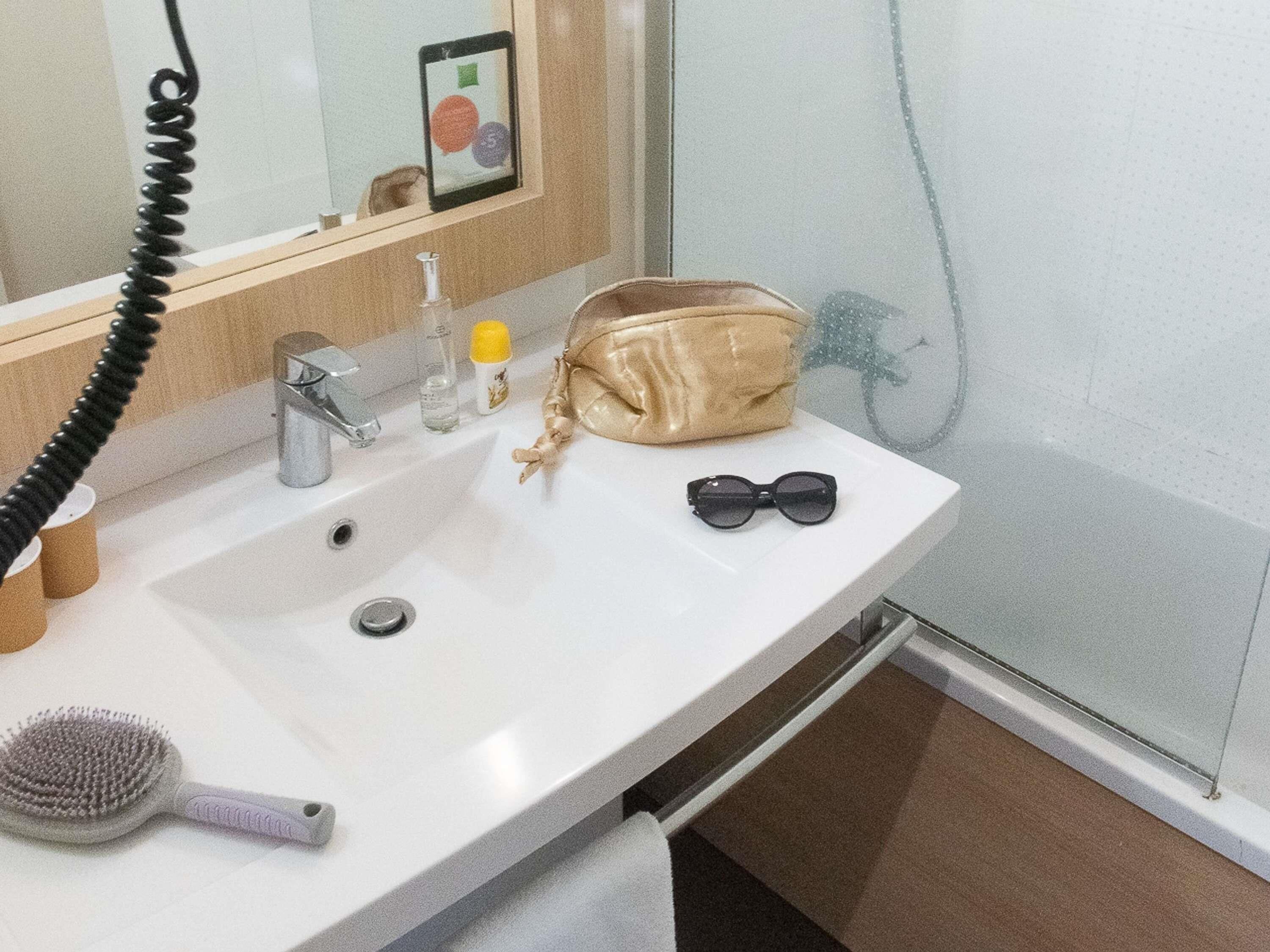 Une salle de bain équipée d’un lavabo, d’un miroir et d’un porte-serviettes.