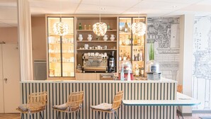 A bar area with a counter, bar stools, shelves with bottles, and a coffee machine.