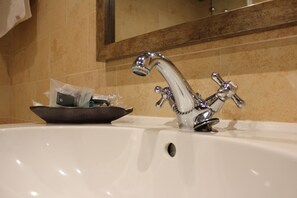Un lavabo de salle de bain avec un robinet chromé et un miroir au-dessus.