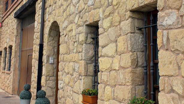 A stone building with a sign reading "Hotel del Rey."