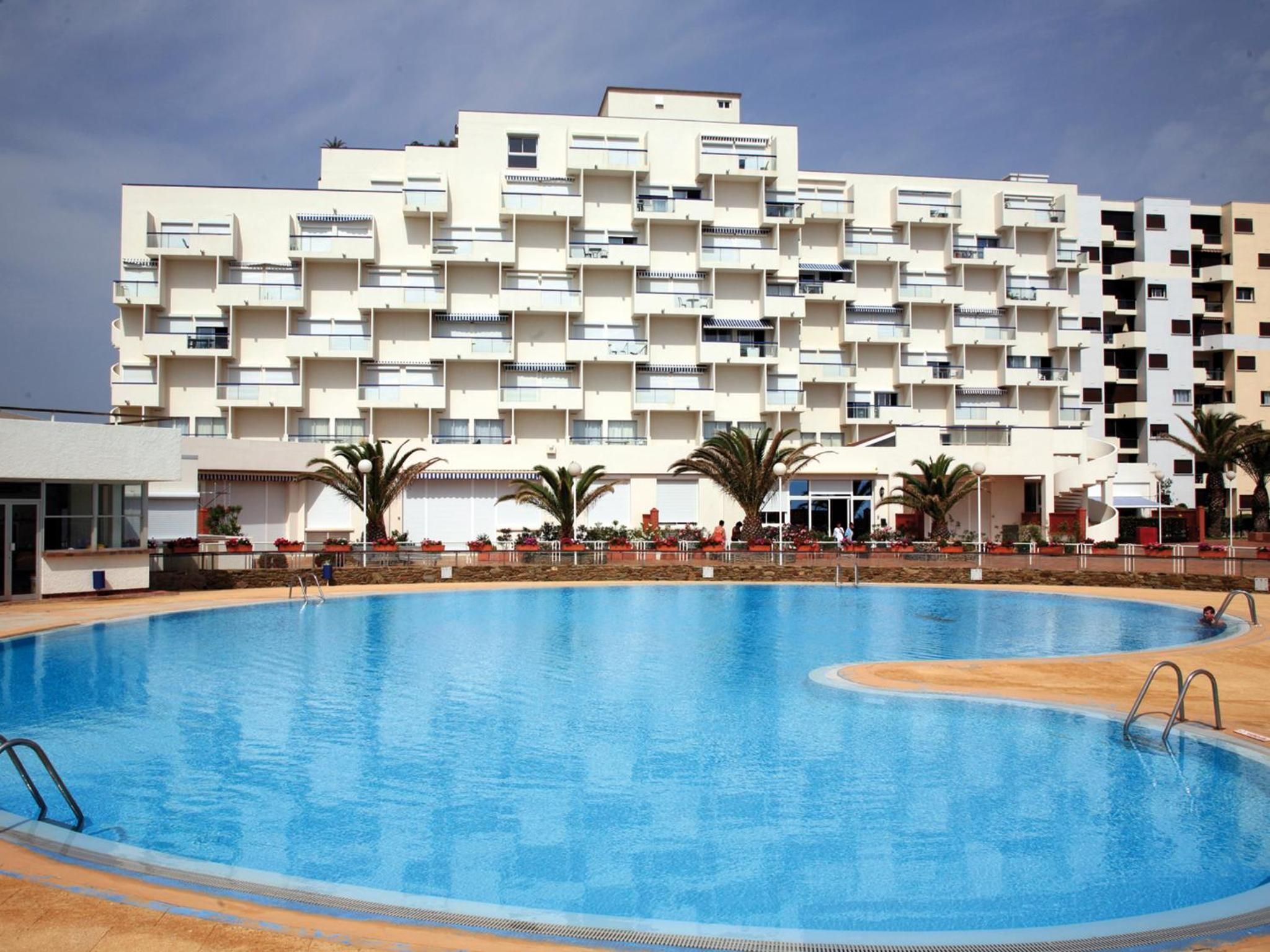 A swimming pool with a modern building in the background.